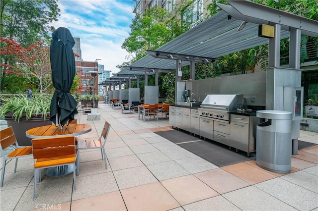 view of patio featuring outdoor dining space, grilling area, exterior kitchen, and a sink