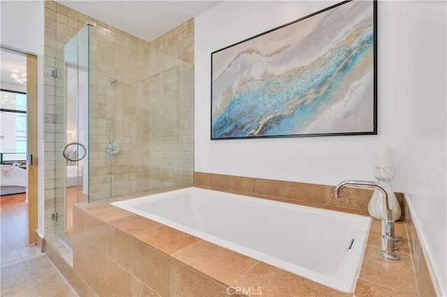 ensuite bathroom with a shower stall, ensuite bath, and tiled bath