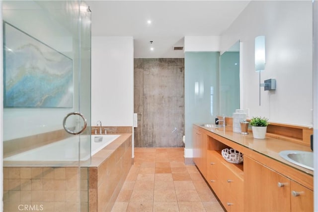 bathroom featuring double vanity, toilet, a sink, visible vents, and tiled tub