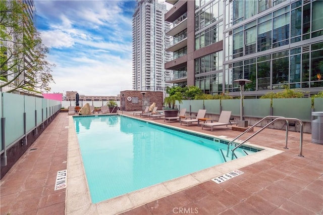 pool featuring fence and a patio area