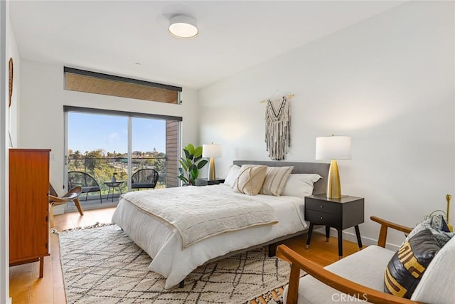 bedroom with light wood finished floors and access to outside