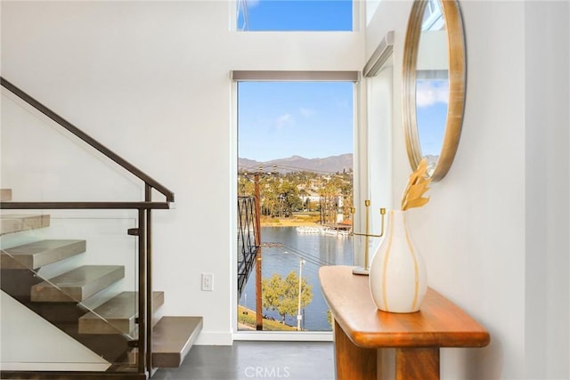 doorway with a water and mountain view and stairs