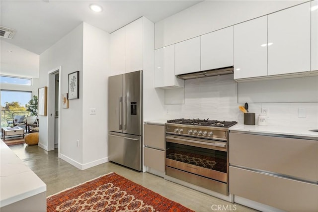 kitchen featuring stainless steel appliances, under cabinet range hood, visible vents, backsplash, and baseboards