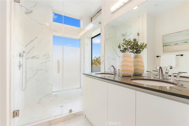 bathroom featuring a marble finish shower, marble finish floor, and a sink