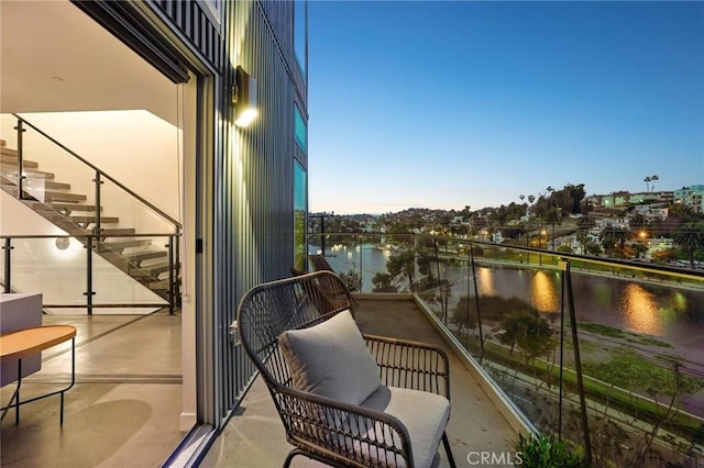 balcony featuring a water view and stairs