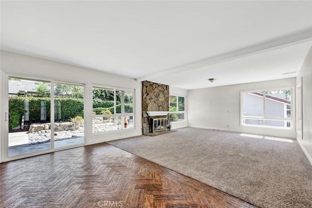 unfurnished living room featuring baseboards and a fireplace