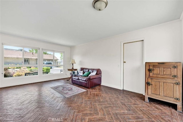 living area with ornamental molding and baseboards