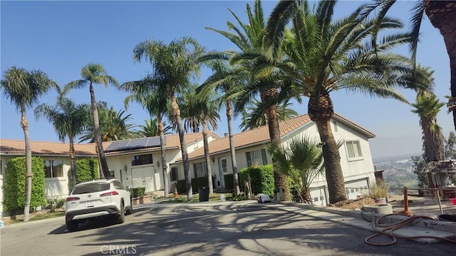 view of front of house featuring roof mounted solar panels and stucco siding
