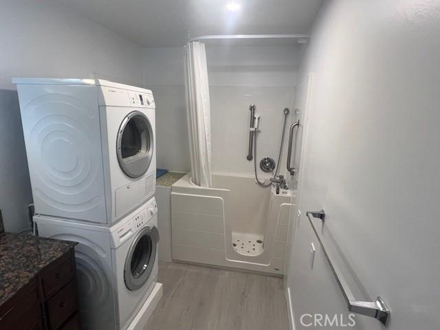 32679 Seagate Dr Unit 308-H, Rancho Palos Verdes, CA 90275 - clothes washing area with light wood-style floors, laundry area, and stacked washer / dryer