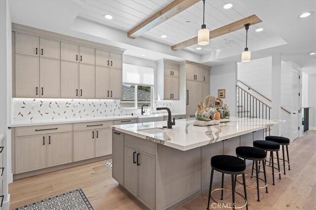 507 N Maria Ave Unit A, Redondo Beach, CA 90277 - kitchen featuring a sink, light wood-type flooring, decorative backsplash, a kitchen bar, and a center island with sink