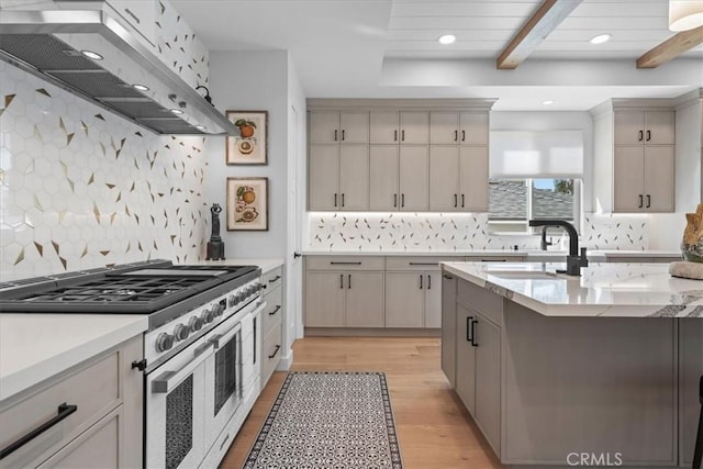 507 N Maria Ave Unit A, Redondo Beach, CA 90277 - kitchen featuring range with two ovens, extractor fan, a sink, decorative backsplash, and light wood-style floors