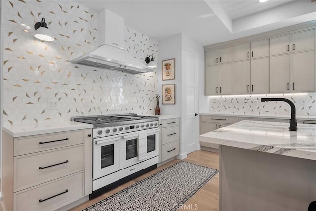 507 N Maria Ave Unit A, Redondo Beach, CA 90277 - kitchen featuring range with two ovens, exhaust hood, backsplash, light wood-style floors, and light stone countertops