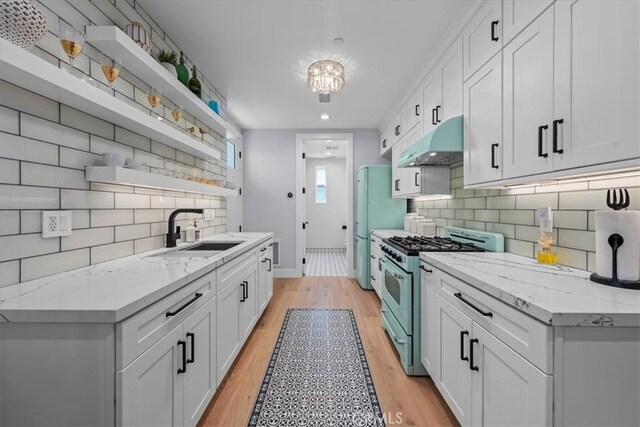 507 N Maria Ave Unit A, Redondo Beach, CA 90277 - kitchen featuring high end range, under cabinet range hood, open shelves, a sink, and light wood-style flooring