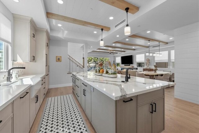 507 N Maria Ave Unit A, Redondo Beach, CA 90277 - kitchen featuring beam ceiling, light wood-type flooring, a center island with sink, decorative light fixtures, and a sink