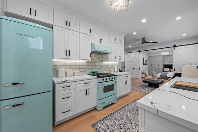 507 N Maria Ave Unit A, Redondo Beach, CA 90277 - kitchen featuring fridge, gas stove, a barn door, under cabinet range hood, and light wood finished floors
