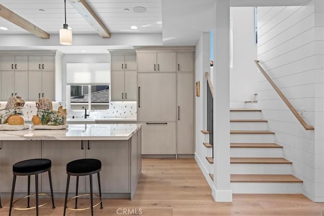 507 N Maria Ave Unit A, Redondo Beach, CA 90277 - kitchen featuring a kitchen breakfast bar, beam ceiling, pendant lighting, light wood-style flooring, and light stone counters