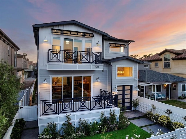 507 N Maria Ave Unit A, Redondo Beach, CA 90277 - back of house at dusk featuring a balcony, fence, and board and batten siding