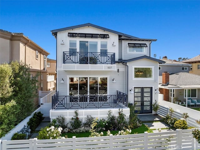 507 N Maria Ave Unit A, Redondo Beach, CA 90277 - rear view of house with french doors, a balcony, a fenced front yard, and board and batten siding