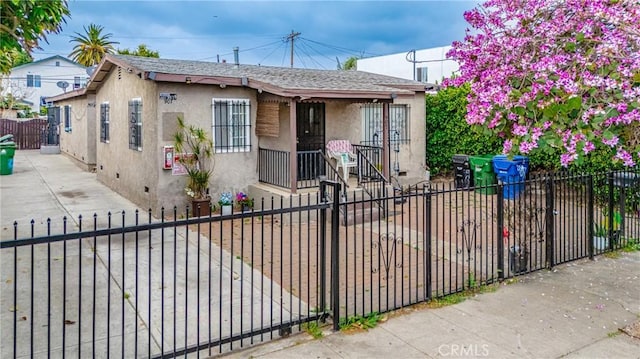 907 E 109th Pl, Los Angeles, CA 90059 - bungalow-style home featuring a fenced front yard, a shingled roof, and stucco siding