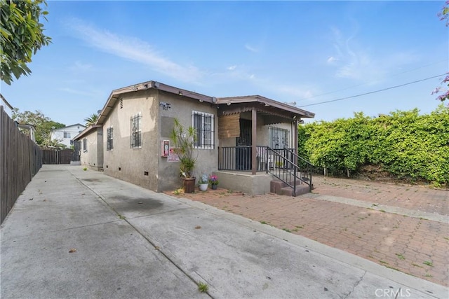 907 E 109th Pl, Los Angeles, CA 90059 - view of front of property with fence, stucco siding, concrete driveway, and crawl space