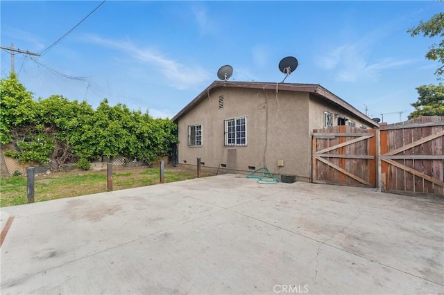907 E 109th Pl, Los Angeles, CA 90059 - back of property featuring a gate, a patio area, stucco siding, and fence