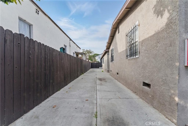907 E 109th Pl, Los Angeles, CA 90059 - view of property exterior with stucco siding, a patio area, fence, and crawl space