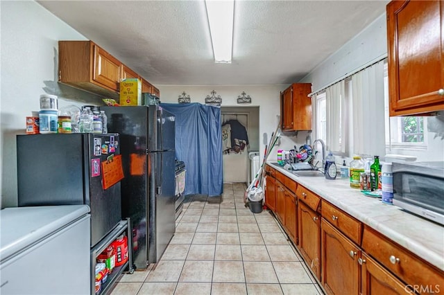 907 E 109th Pl, Los Angeles, CA 90059 - kitchen featuring a sink, light tile patterned floors, brown cabinets, and light countertops