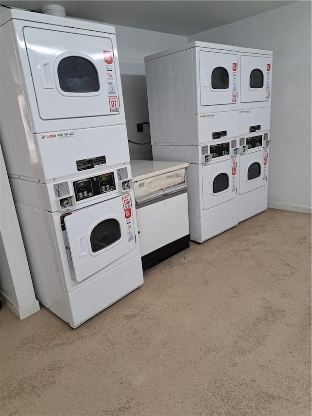 common laundry area with separate washer and dryer, stacked washer and clothes dryer, and baseboards