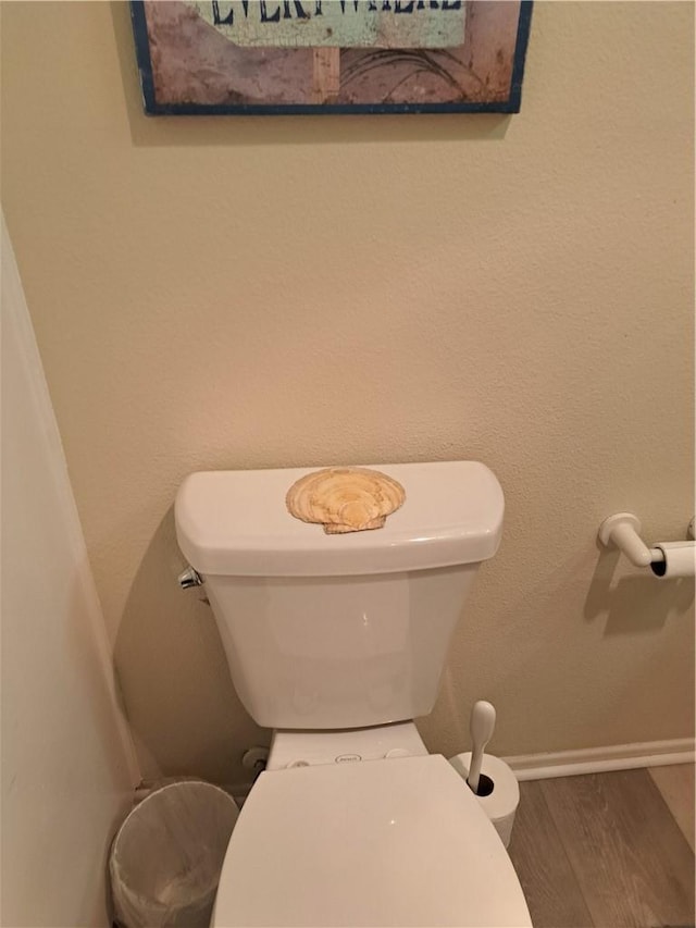 bathroom featuring baseboards, toilet, and wood finished floors
