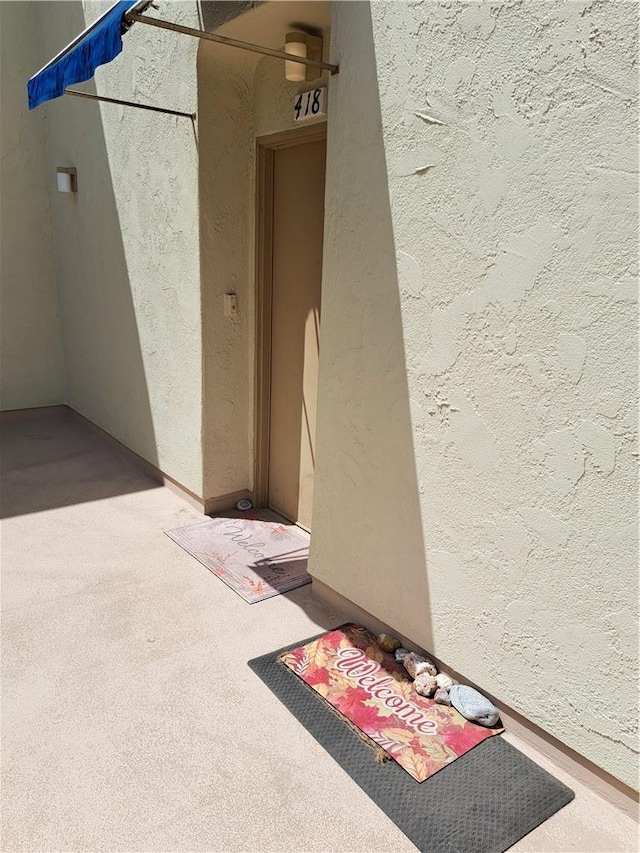 entrance to property featuring stucco siding
