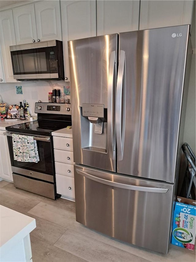 kitchen featuring light countertops, white cabinetry, and appliances with stainless steel finishes