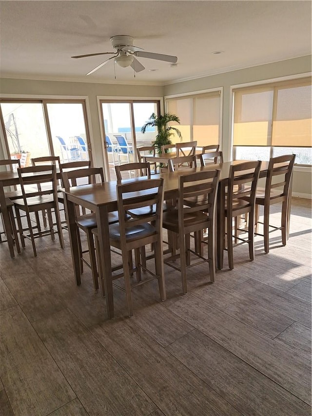 711 Pacific Coast Hwy Unit 418, Huntington Beach, CA 92648 - dining space with ceiling fan, crown molding, and dark wood-style flooring