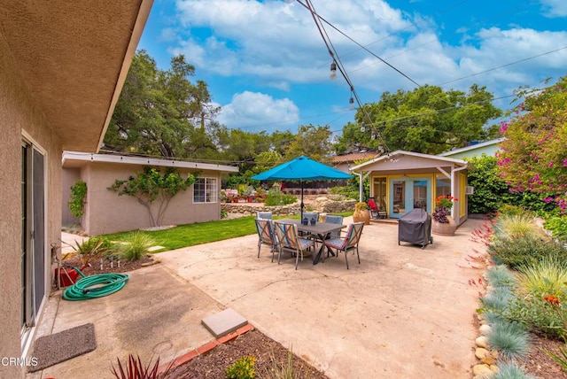 view of patio with area for grilling and an outbuilding