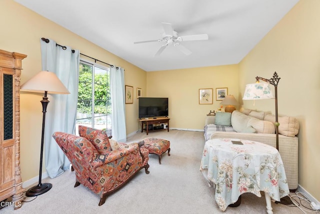 carpeted living room with ceiling fan and baseboards