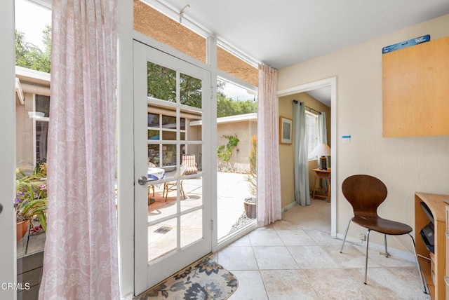 doorway featuring baseboards and tile patterned flooring
