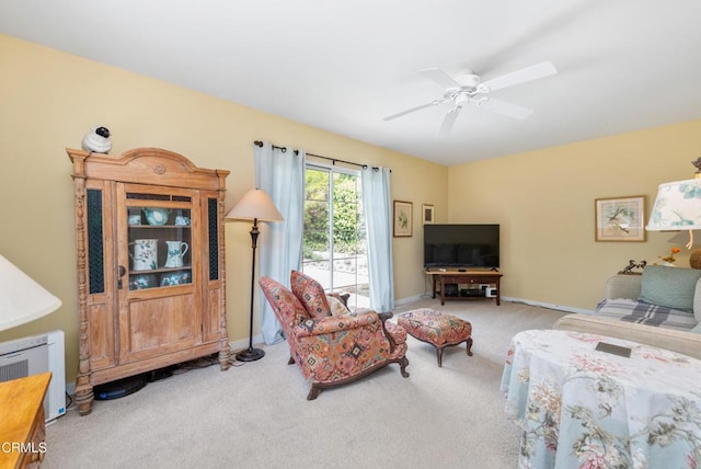 living area featuring carpet floors, ceiling fan, and baseboards