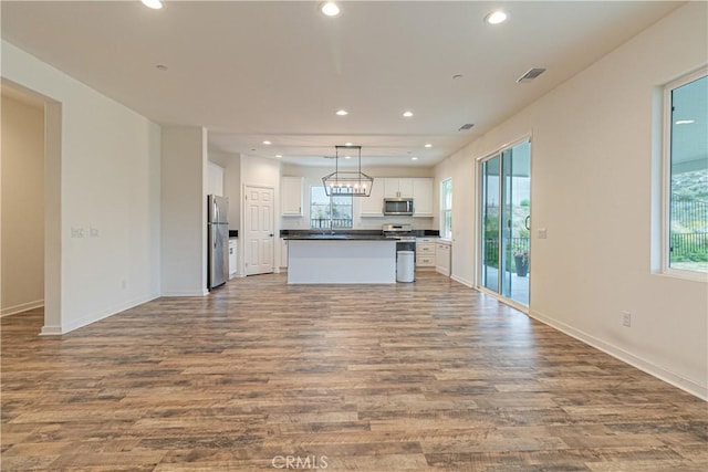 kitchen with stainless steel appliances, wood finished floors, and open floor plan