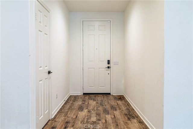 entryway with dark wood-type flooring and baseboards