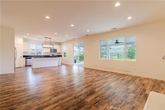 unfurnished living room featuring visible vents, wood finished floors, baseboards, and recessed lighting