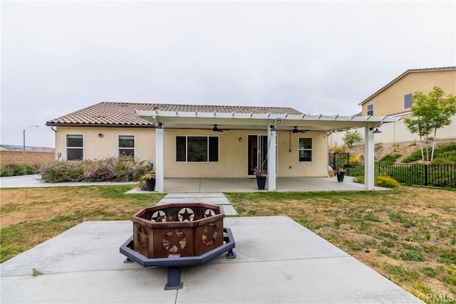 view of front of house featuring fence, a patio area, a front yard, a ceiling fan, and an outdoor fire pit