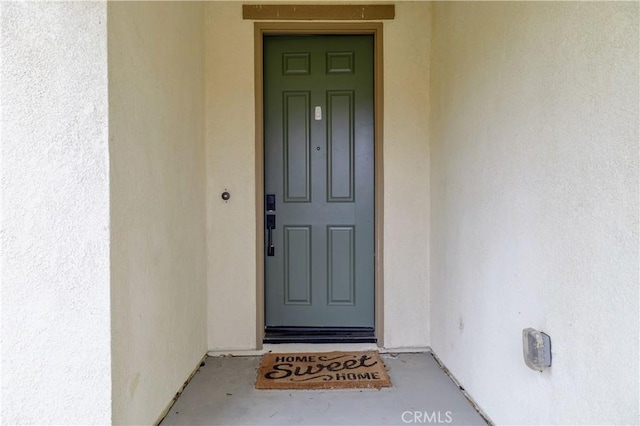 view of exterior entry featuring stucco siding