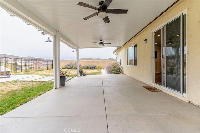 view of patio with fence and ceiling fan