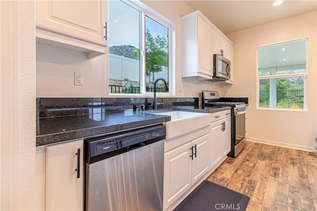 kitchen with a sink, light wood-style floors, a healthy amount of sunlight, and appliances with stainless steel finishes