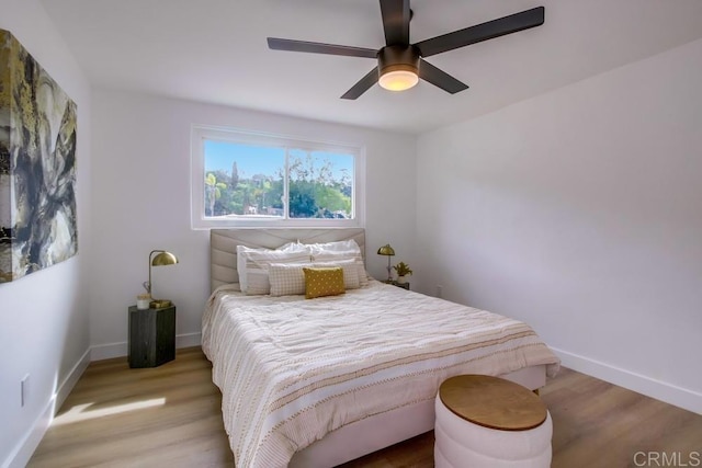 bedroom featuring wood finished floors, baseboards, and ceiling fan