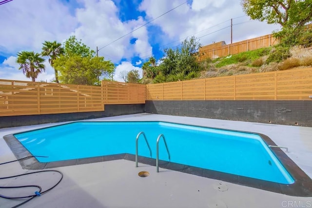 view of pool with a fenced backyard and a patio