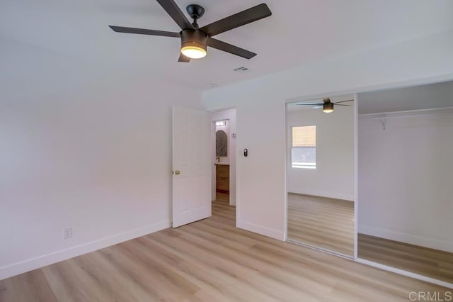 unfurnished bedroom with light wood-style floors, a closet, baseboards, and ceiling fan