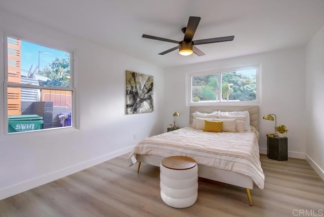 bedroom featuring light wood-style flooring, baseboards, and ceiling fan