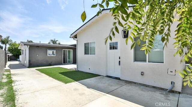 10301 Antigua St, Anaheim, CA 92804 - rear view of property featuring fence, stucco siding, a yard, and a patio area
