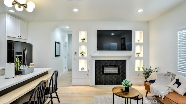 10301 Antigua St, Anaheim, CA 92804 - living room with light wood-style floors, arched walkways, an inviting chandelier, recessed lighting, and built in features