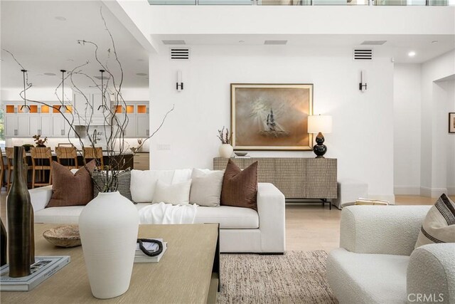 living area featuring visible vents and light wood-style flooring